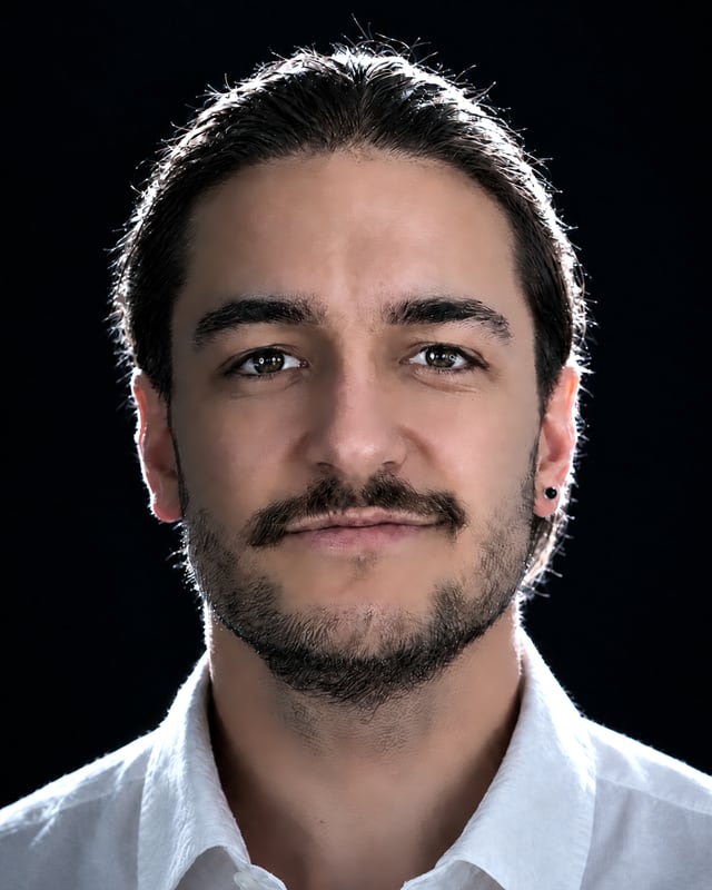 Porträt von Lukas Mehlstäubl, Geschäftsführer der Rolutec GmbH, im weißen Hemd vor dunklem Hintergrund